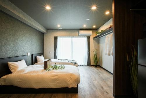 a bedroom with two beds and a large window at VACATION RENT Kanazawa - Vacation STAY 69560v in Kanazawa
