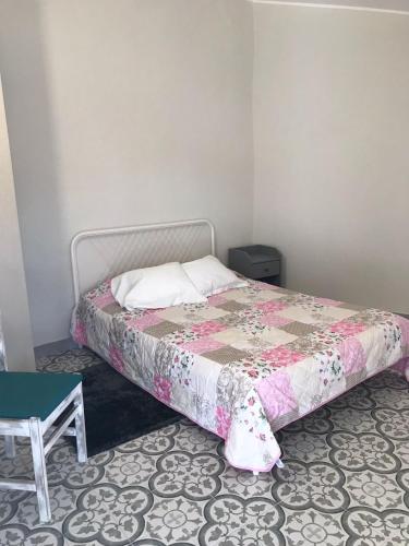 a bedroom with a bed with a pink bedspread and a table at Harrisko etxea in Viana do Castelo
