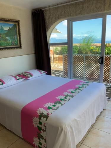 a bedroom with a bed with a view of the ocean at Tahitininalodge 1 in Faaa