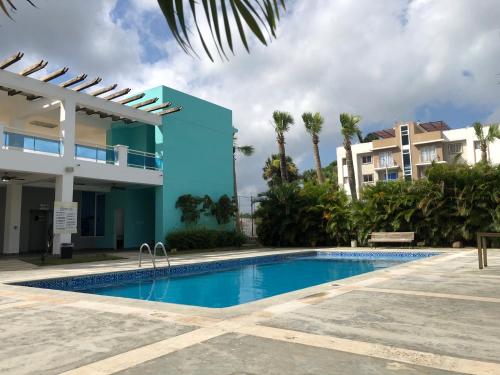 a swimming pool in front of a building at Oasis Palma Real santiago, Republica Dominicana in Santiago de los Caballeros
