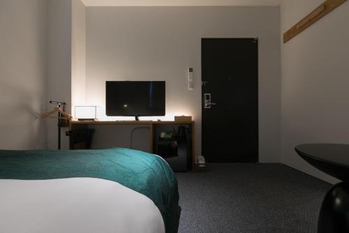 a bedroom with a bed and a television on a desk at Design Hotel Kyoto Fuyacho - Vacation STAY 65938v in Kyoto