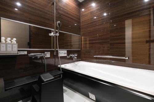 a bath tub in a bathroom with wooden walls at Design Hotel Kyoto Fuyacho - Vacation STAY 65938v in Kyoto