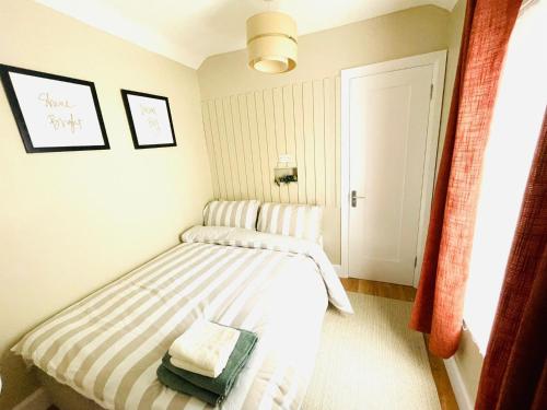 Dormitorio pequeño con cama con manta a rayas en Calla's place, en Derry Londonderry