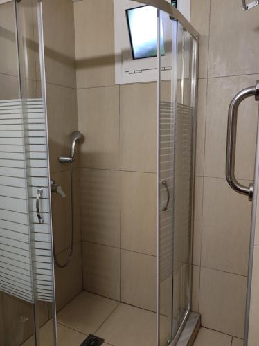 a shower with a glass door with a television in it at Hotel Ritsa in Kamena Vourla