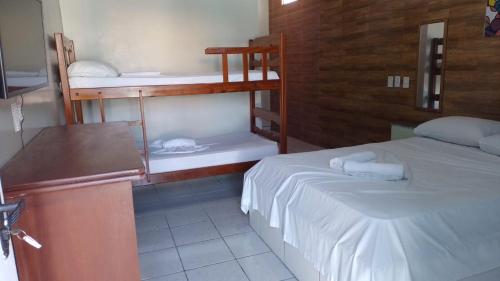 a room with two beds and a desk and a podium at Pousada Ilha do Sol in Salinópolis