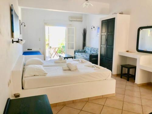 a large white bedroom with a large bed in a room at Agios Pavlos Studios in Aegiali