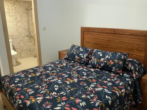 - une chambre dotée d'un lit avec un couvre-lit floral dans l'établissement Luxueux appartement avec piscine à la Marina Saidia, à Saïdia