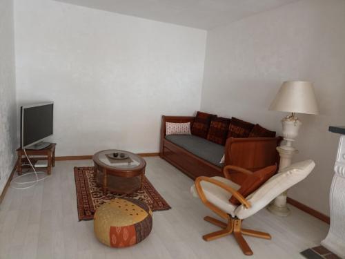 ein Wohnzimmer mit einem Sofa und einem Stuhl in der Unterkunft appartement avec balcon in Hargarten-aux-Mines