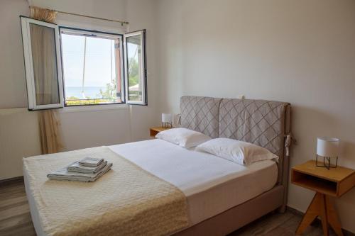 - une chambre avec un grand lit et une fenêtre dans l'établissement Almyros Aktis seaview apartment, à Kalamata