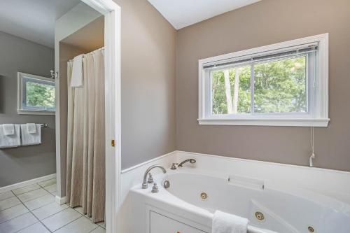 a white bathroom with a tub and a window at Pleasant Street Retreat in Boyne City