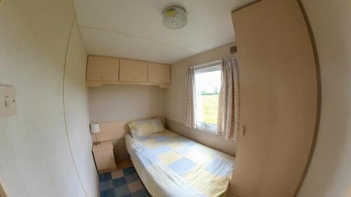 Cette petite chambre comprend un lit et une fenêtre. dans l'établissement DEVIL'S BIT accommodation, à Killea