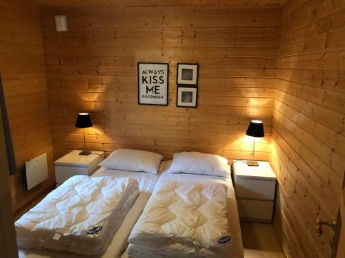 a bedroom with two beds and two night stands at Solvang World Heritage Camping in Eidsdal