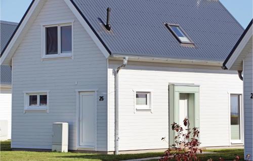 une maison blanche avec un toit gris dans l'établissement Awesome Home In Ostseeresort Olpenitz, à Olpenitz
