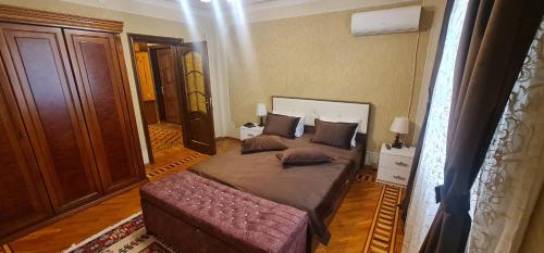 a bedroom with a large bed and a couch at Gold Wall Apartment in Baku
