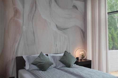 Un dormitorio con una cama con un cuadro en la pared. en Green Valley Loft, en Jūrmala