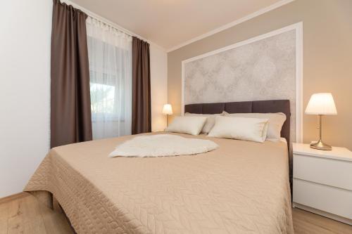 biała sypialnia z dużym łóżkiem i oknem w obiekcie Apartment Miko w mieście Sveti Ivan Dobrinjski