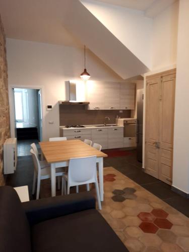 a kitchen with a table and chairs in a room at Appartamento su palazzina storica in centro a Sant'Antioco in SantʼAntìoco
