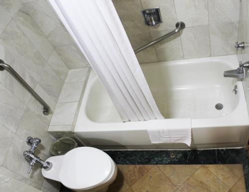a bathroom with a toilet and a bath tub and a toilet at Hotel Las Americas in Guatemala