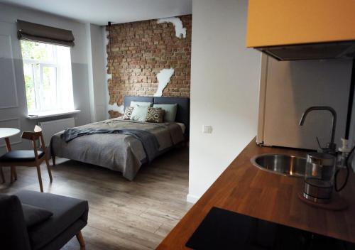 Il comprend une chambre avec un lit et une cuisine avec un évier. dans l'établissement Comfortable design apartment on Vilanu, à Riga