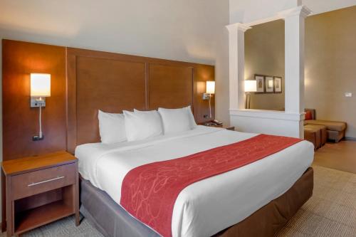 a hotel room with a large bed with a red blanket at Comfort Suites St George - University Area in St. George