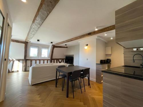 une cuisine et un salon avec une table et un lit dans l'établissement Appartement les hirondelles, à Honfleur