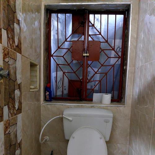 Amarossi Hippo-Studio Terrace Apartment, Mtwapa في متوابا: حمام مع مرحاض ونافذة