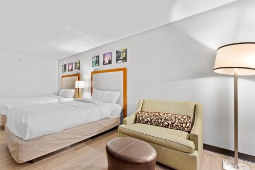 a bedroom with a bed and a chair at Days Inn by Wyndham Erie in Erie