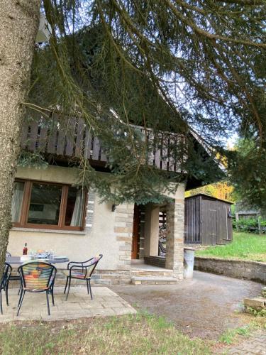 a table and chairs in front of a house at Kleines Haus am Waldrand, Haustiere auf Nachfrage in Klughaus