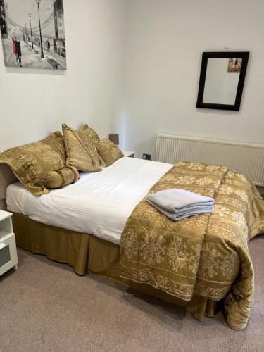 リバプールにあるNo 4 AT SANDRINGHAM - LARGE 2 BED NEAR SEFTON PARKのベッドルーム1室(金のシーツと枕が備わるベッド1台付)