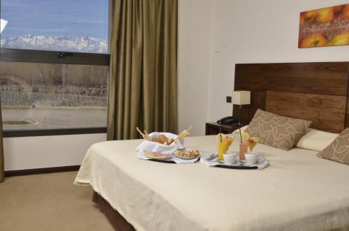 una habitación de hotel con una bandeja de comida en una cama en Fuente Mayor Hotel & Casino en Vista Flores