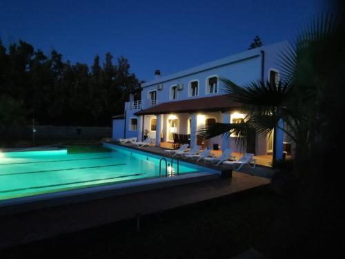 une villa avec une piscine la nuit dans l'établissement Villa Maria Marchesana, à Pezzi di Gala