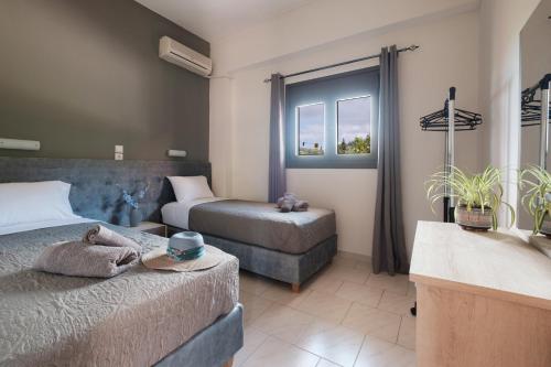 a bedroom with two beds and a bathroom with a tub at Mouzakitis Apartments 3 in Arillas
