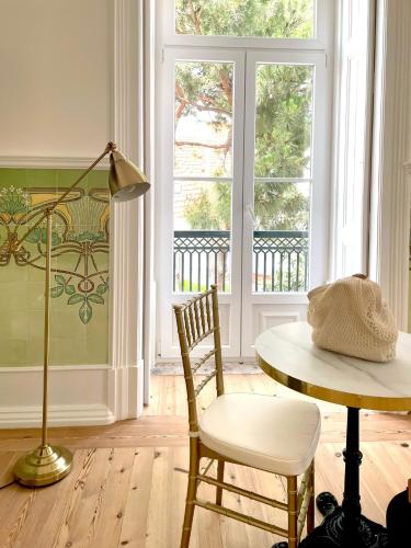a room with a table and a chair and a lamp at Palácio do Visconde - The Coffee Experience in Lisbon