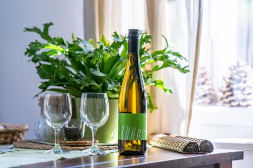 a bottle of wine sitting on a table with two glasses at Vila Heide in Česká Kamenice