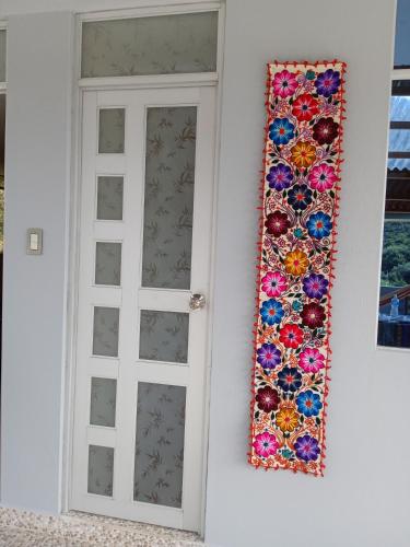 a door with a mosaic curtain next to a window at Ecolodge Casa del Montañista in Huaraz