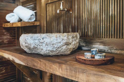 a bathroom with a stone sink and candles on a wooden counter at Embajada Universal By La Eufemia Group in Huay Pix