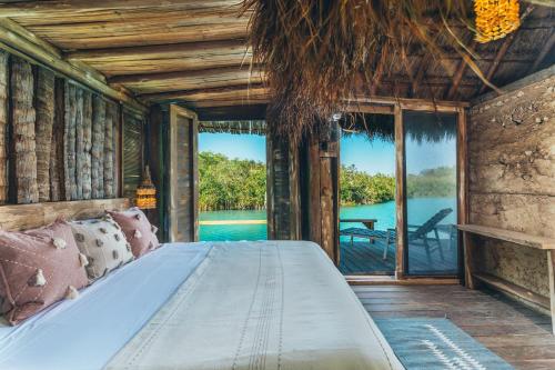 a bed in a room with a view of the water at Embajada Universal By La Eufemia Group in Huay Pix