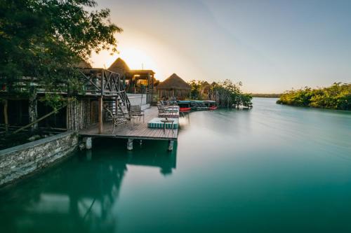 a house on the water with a dock in the water at Embajada Universal By La Eufemia Group in Huay Pix