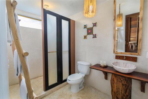 a bathroom with a toilet and a sink and a mirror at Embajada Universal By La Eufemia Group in Huay Pix