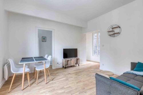 a living room with a couch and a table and chairs at The New White Appart'Hôtel Vitry - Next to Paris in Vitry-sur-Seine