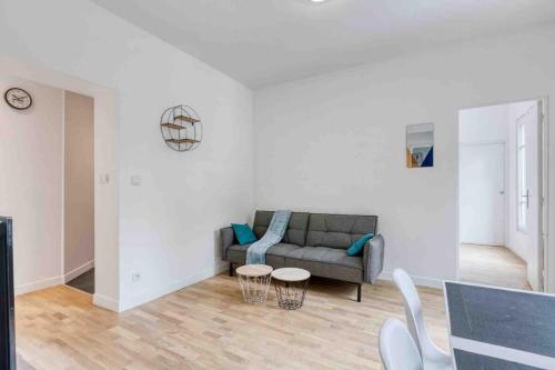 a living room with a couch and a table at The New White Appart'Hôtel Vitry - Next to Paris in Vitry-sur-Seine