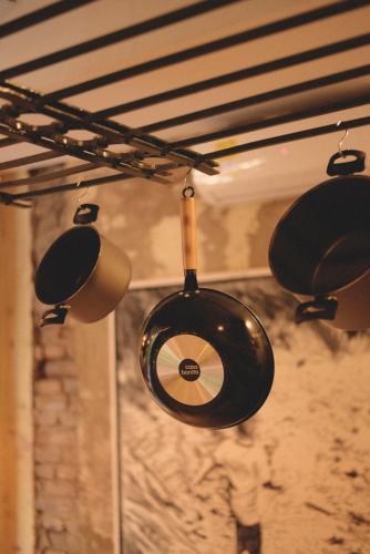 a group of pots and pans hanging from a ceiling at La Casa del Totumo in Santa Marta