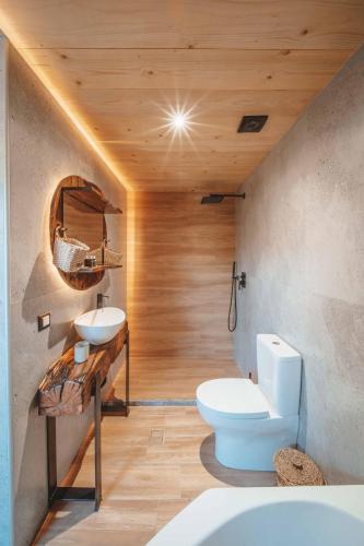 a bathroom with a white toilet and a sink at Krassopsychia Apartments in Krásion
