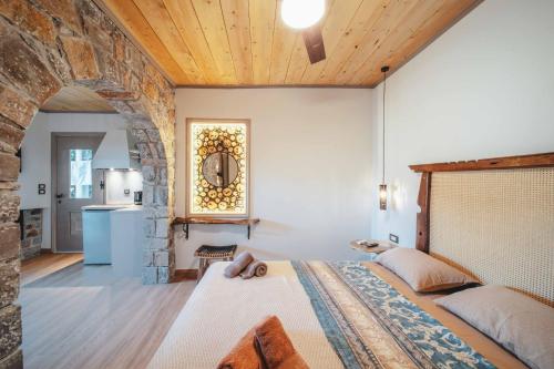 a bedroom with a bed and a stone wall at Krassopsychia Apartments in Krásion
