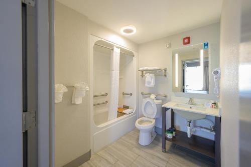 a bathroom with a toilet and a sink and a mirror at Hawthorn Suites by Wyndham Panama City Beach FL in Panama City Beach