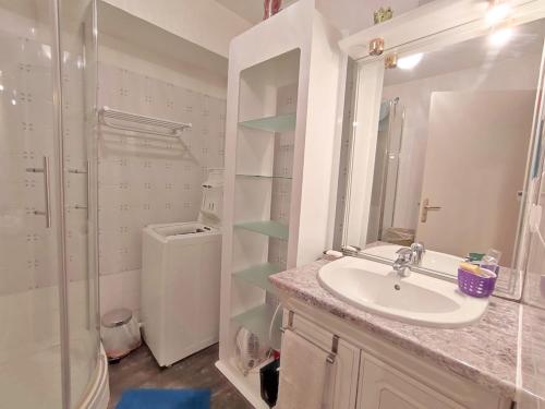 La salle de bains blanche est pourvue d'un lavabo et d'une douche. dans l'établissement Chez Jacques et Christine, charmant T2 bis, parking gratuit, proche thermes, wifi, 4 personnes, à Luchon