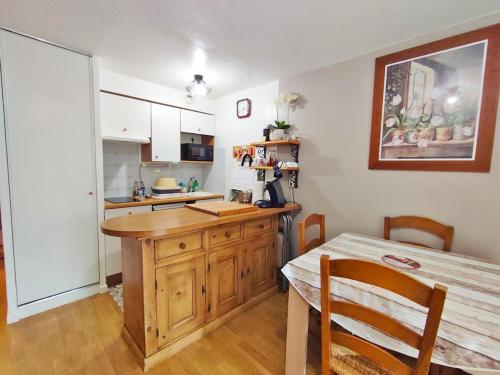 une cuisine avec une table en bois et une salle à manger dans l'établissement Au doux refuge, charmant T2 bis, parking gratuit, proche thermes, 6 personnes, à Luchon