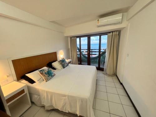 1 dormitorio con cama y ventana grande en Casa na Beira da Praia da Pipa Beach House Luxury, en Pipa