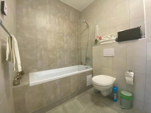 uma casa de banho com uma banheira e um WC e uma banheira em ForestHouse 1 em Timisoara