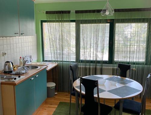 - une cuisine avec une table, une table et des chaises dans l'établissement Apartment Vila Jezero, à Zlatibor